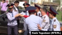 Police take away a protester in the Almaty district of Duman.