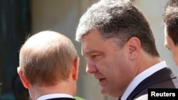 Ukrainian President-elect Petro Poroshenko (right) talks to Russian President Vladimir Putin after a group photo during the 70th anniversary of the D-Day landings in Benouville on June 6.