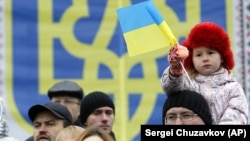 Дівчинка на плечах у батька під час мітингу в Києві