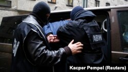 Polish Internal Security Agency (ABW) officers escort a man arrested on suspicion of spying. (illustrative photo)