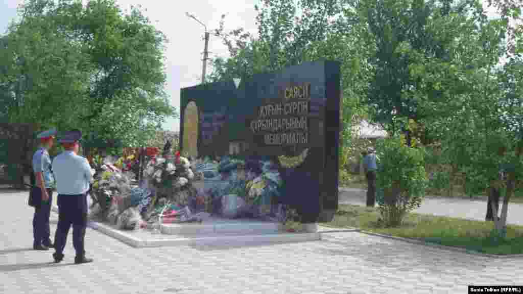 Мемориал маңын бақылап жүрген полиция қызметкерлері жұрт қойып кеткен гүлдерге қарап тұр. Атырау, 31 мамыр 2016 жыл. 