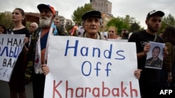 Протестующие несли плакаты с лозунгами «Руки прочь от Арцаха» и пытались сжечь плакаты с изображениями президентов Армении, России и Азербайджана, чего полиция не допустила