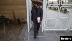 Conservative Iranian parliamentarian Ali Motahari leaves Interior Ministry building in Tehran after registering as a legislative candidate for Iran's 2012 election.