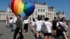Activists walk past a large rainbow-colored heart erected in front of the country's parliament in Budapest on July 8. The activists were protesting against the recently passed law they say discriminates and marginalizes LGBT people.