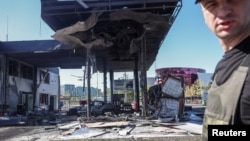 A Ukrainian police officer attends the site of a gas station hit by a Russian drone strike in Kyiv on September 10.