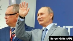 Russian President Vladimir Putin waves to the crowd at the Russian Formula One Grand Prix in Sochi on September 30.