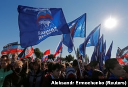 People hold flags of Russia's ruling United Russia party during a rally at the war memorial complex of Savur-Mohyla marking the 78th anniversary of the liberation of the Donbas region from Nazi occupation during World War II, outside the separatist-held Ukrainian city of Donetsk on September 8.