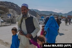 Afghan nationals make their way back across the Afghan border at the Torkham crossing on May 5.