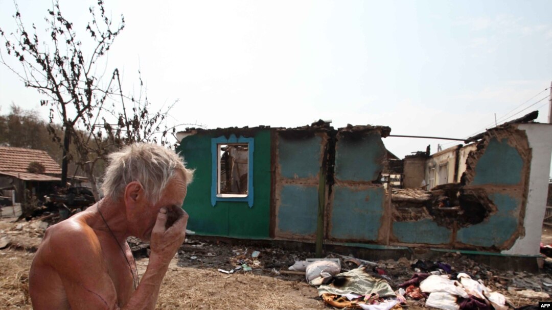 A man stands near the charred remains of his burned-out home in Voronezh on August 3.