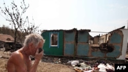 A man stands near the charred remains of his burned-out home in Voronezh on August 3.