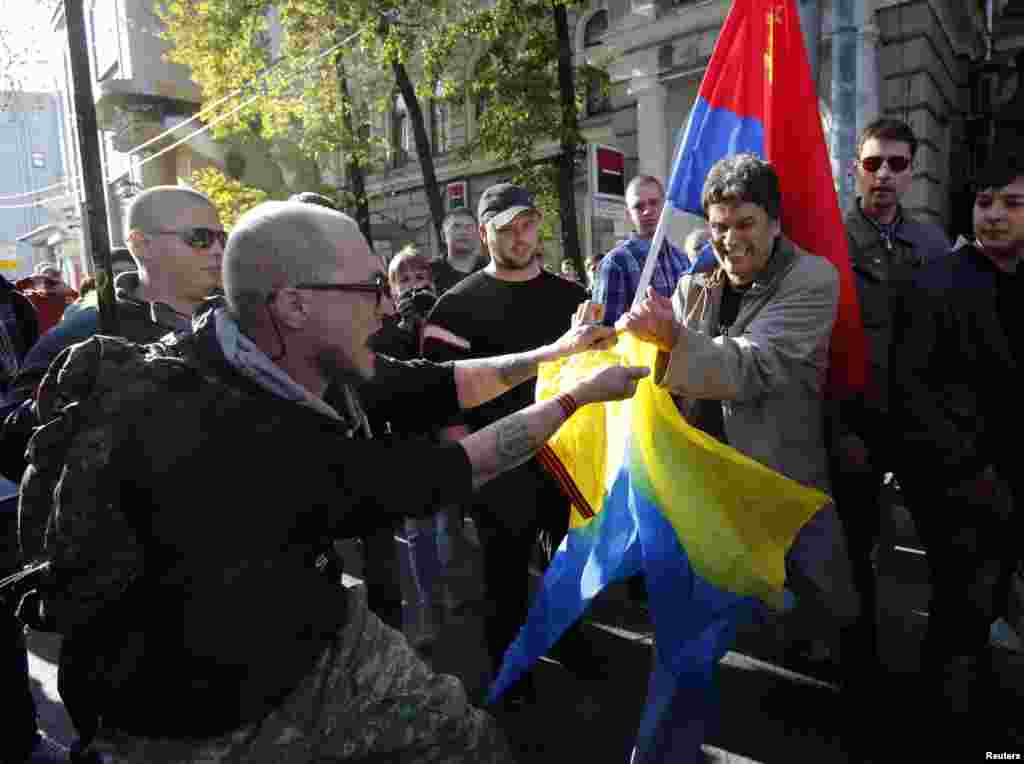 A counterprotester tries to tear a Ukrainian flag. Small scuffles broke out between peace marchers and counterprotesters who turned out in support of the self-proclaimed republics of Donetsk and Luhansk. 