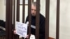 Former Moscow city duma Deputy Aleksei Gorinov appears in court on November 27 with a handmade poster calling for an end to the war in Ukraine.