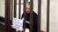 Former Moscow city duma Deputy Aleksei Gorinov appears in court on November 27 with a handmade poster calling for an end to the war in Ukraine.