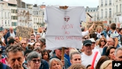 Протестующий держит футболку с надписью «Нет пропуска для здоровья» во время демонстрации в Байонне, на юго-западе Франции, в субботу, 7 августа 2021 года. 