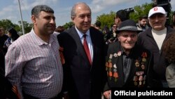 Armenia - President Armen Sarkissian poses for a photograph with a World War II veteran and his relatives at Yerevan's Victory Park, 9 May 2018.