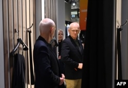 2022 წლის ნობელის პრემიის ლაურეატი მშვიდობის დარგში ალეს ბიალიაცკი მეუღლესთან, ნატალია პინჩუკთან ერთად, ახალ პიჯაკს ისინჯავს ვილნიუსის სავაჭრო ცენტრში. 2025 წლის 14 დეკემბერი, გათავისუფლებიდან მეორე დღე. ფოტო: AFP