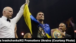 Український боксер Олександр Усик, який завоював титул чемпіона світу за версіями Всесвітньої боксерської ради (WBC), Всесвітньої боксерської організації (WBO), Всесвітньої боксерської асоціації (WBA) і Міжнародної боксерської федерації (IBF) у вазі до 90,71 кілограма в об'єднавчому бою з російським боксером Муратом Гассіевим, у фіналі Всесвітньої боксерської суперсерії WBSS. Москва, 22 липня 2018 року 