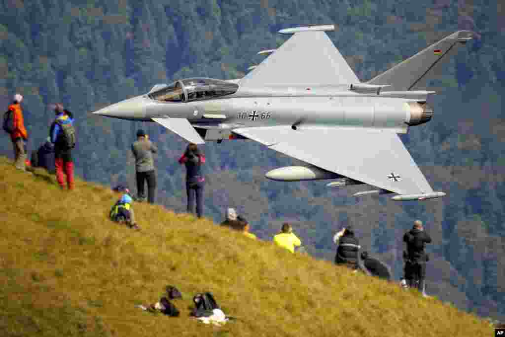 Ljubitelji avijacije prosmatraju prelet aviona Eurofighter Typhoon njemačkog ratnog zrakoplovstva tokom predstave vojne i akrobatske avijacije na planini Bučegi, Rumunija, 26. augusta.
