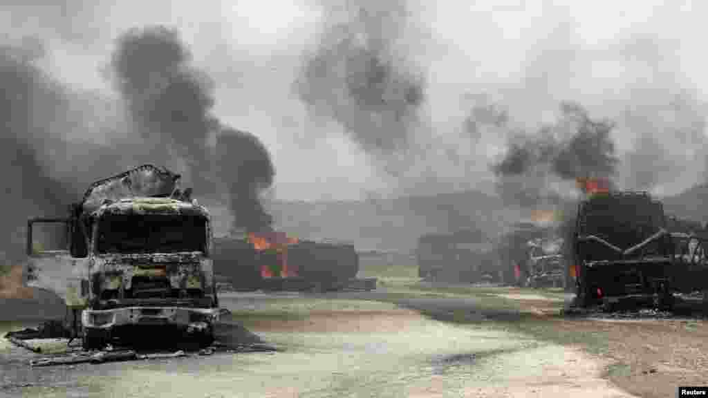 Smoke rises from burning NATO supply trucks in Samangan Province on July 18. A bomb planted by the Taliban destroyed 22 NATO trucks carrying supplies to their forces in northern Afghanistan. (REUTERS)