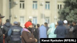 Қырғызстандағы парламент сайлауынан кейін басталған наразылық акциялары қатысушыларының жанынан өтіп бара жатқан әйел. Бішкек, 10 қазан 2020 жыл.
