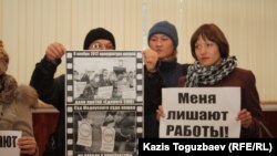 Журналисты закрытой по решению суда оппозиционной газеты "Голос республики" держат плакаты в фойе здания суда. Алматы, 22 февраля 2013 года.