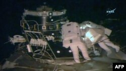 U.S. astronauts Peggy Whitson (left) and Shane Kimbrough work outside the International Space Station last month.