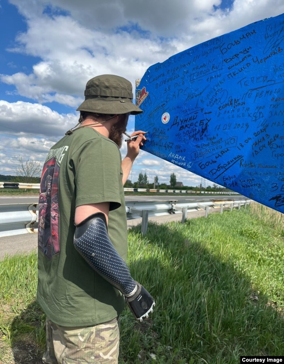 Shota Bitadze duke nënshkruar në një tabelë në hyrje të Ukrainës.