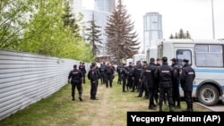 Police officers stand in front of a fence to block demonstrators protesting the planned church on May 16.