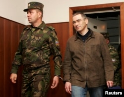 Khodorkovsky is escorted by a security officer before an appeal hearing against his fraud conviction in Moscow City Court on September 20, 2005.