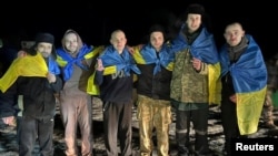 Ukrainian POWs pose after a prisoner swap at an unknown location in Ukraine on January 3. 