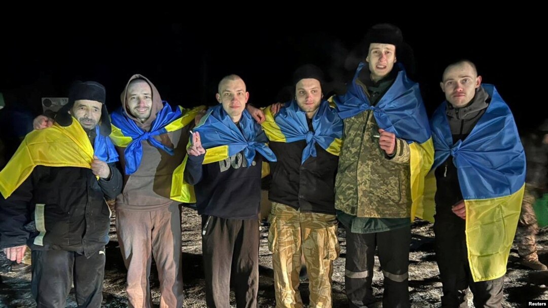 Току що освободени украински военнопленници позират със знамена на родината си, 3 януари 2023 г.
