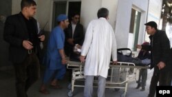 Медики и сотрудники сил безопасности рядом с раненым у больницы в Кабуле. 1 марта 2017 года.