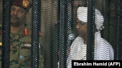 Суданский авторитарный правитель Омар аль-Башир в клетке подсудимого при открытии суда над ним по делу о коррупции. Хартум, август 2019