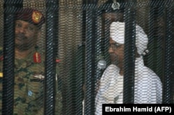 Omar al-Bashir sűrű rácsok mögött a kartúmi tárgyalásán, 2019. augusztus 19-én.