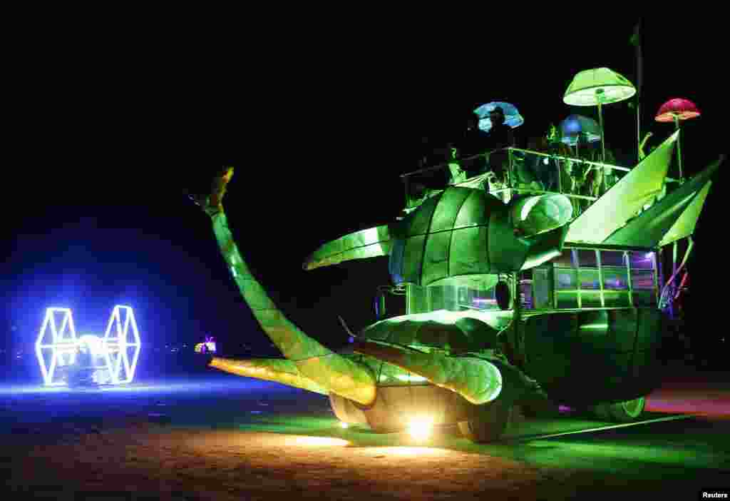 Mutant vehicles drive across the main area during the Burning Man 2013 arts and music festival in the Black Rock Desert of Nevada.