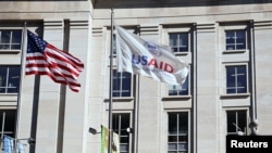 Американський прапор та прапор USAID майорять біля будівлі USAID у Вашингтоні, округ Колумбія, США, 1 лютого 2025 року