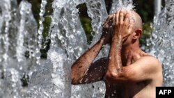 Зайти в фонтан на городской площади, чтобы остыть, стало обычным делом в необычайно жаркие дни в конце этого лета. Колмар, восток Франции, 21 августа 2023 