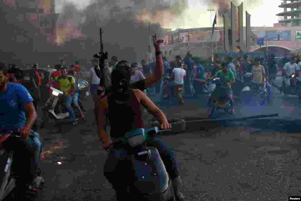 Sunni Muslim gunmen roam the streets and block roads with burning tires, expressing their solidarity with Salafist leader Ahmad al-Assir, in Tripoli, northern Lebanon. (Reuters/Omar Ibrahim)