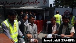 Afghan health workers transport a wounded man to a hospital after a bomb explosion targeted a police station in a residential area of Kabul on August 7.