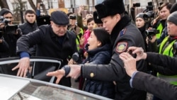 Полиция қызметкерлері журналист Инга Иманбайды көлікке күштеп отырғызып жатыр. Алматы, 22 ақпан 2020 жыл.