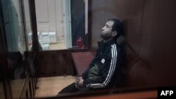 Unul dintre bărbații suspectați de realizarea atacului de la sala din concerte din Moscova, stă în cușca inculpaților în timpul audierilor pentru arestarea preventivă.