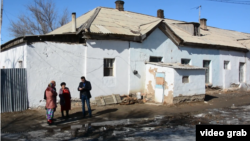 Оралманы рядом со зданием бывшего детского сада, в котором они живут и которое местные власти признали аварийным. Кызылординская область, февраль 2017 года.