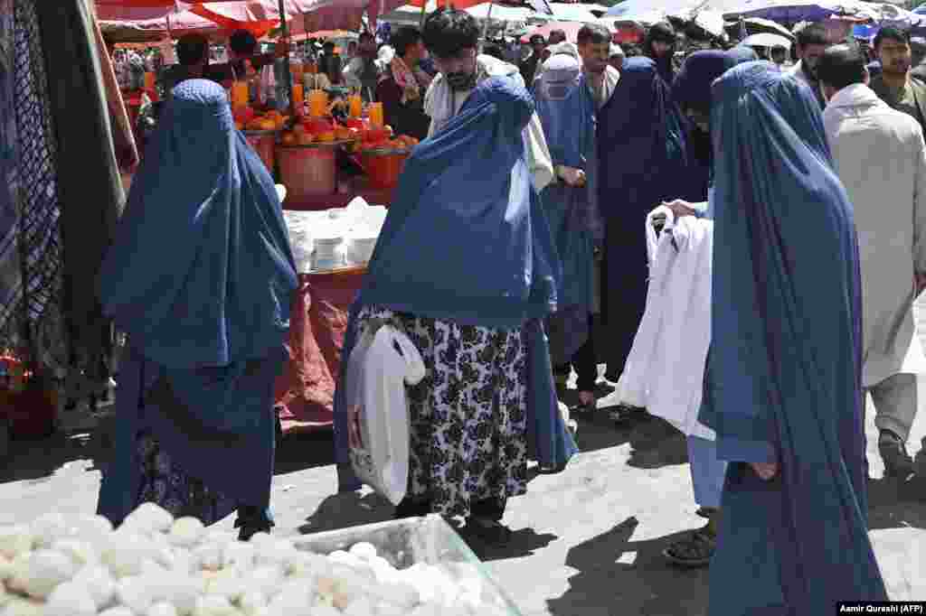 Femeile purtând burqa fac cumpărături într-o o piață din Kabul pe 28 august. Vânzările de burqa - obligatorii pentru femei în perioada anterioară de conducere a talibanilor - au crescut în ultimele săptămâni.