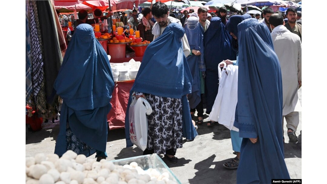 Femei îmbrăcate în burqa, în timp ce își fac cumpărăturile la piața din centrul orașului Kabul, 28 august 2021. Întoarcerea talibanilor la putere le sperie pe multe dintre acestea.