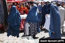 Burqa-clad women shop at a market in downtown Kabul on August 28, weeks after the Taliban's stunning military takeover of Afghanistan.