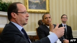 U.S. President Barack Obama (right) listens as French President Francois Hollande speaks during their meeting in the White House on May 18.
