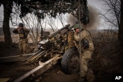 Украинские артиллеристы ведут огонь из гаубицы М101 по российским позициям на передовой, недалеко от Авдеевки, Донецкая область, 22 марта 2024 года