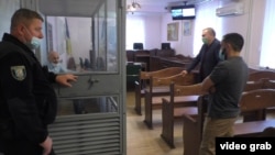 Владислав Мангер та Руслан Агаєв спілкуються під час перерви у судовому засіданні