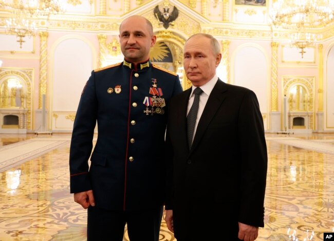 Vladimir Putin (a destra) posa con il leader separatista ucraino Artem Zhoga al Cremlino l'8 dicembre.