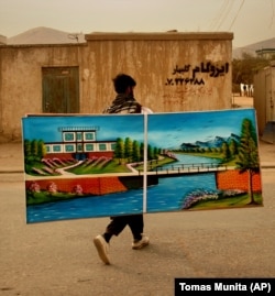 A painter selling his work, which features a landscape devoid of people, in Kabul in 2005